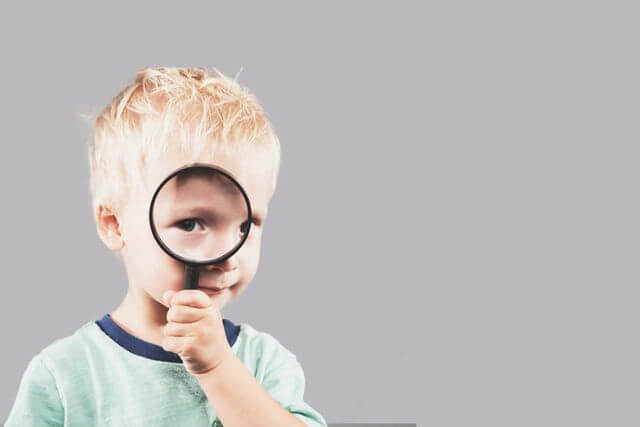 boy with magnifying glass for vision therapy