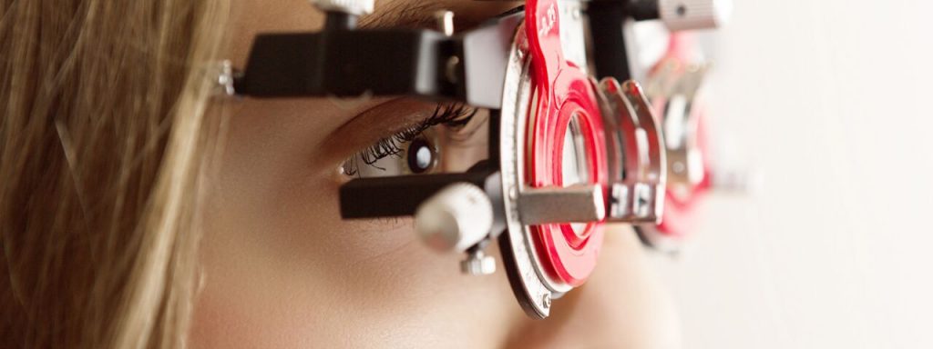 Optometrist giving eye exam to boy in Ogden, UT