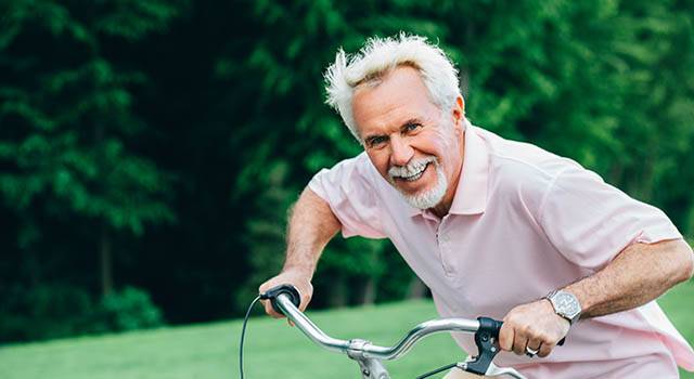 Lively Older Man Riding His Bicycle, Laughs And Enjoys Life. Sen