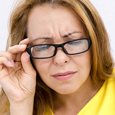 Woman, wearing eyeglasses, frowning