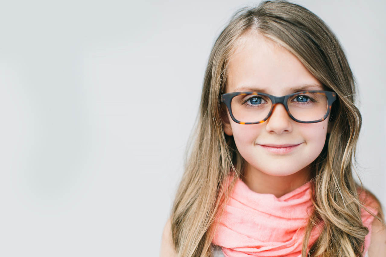 Child smiling wearing glasses