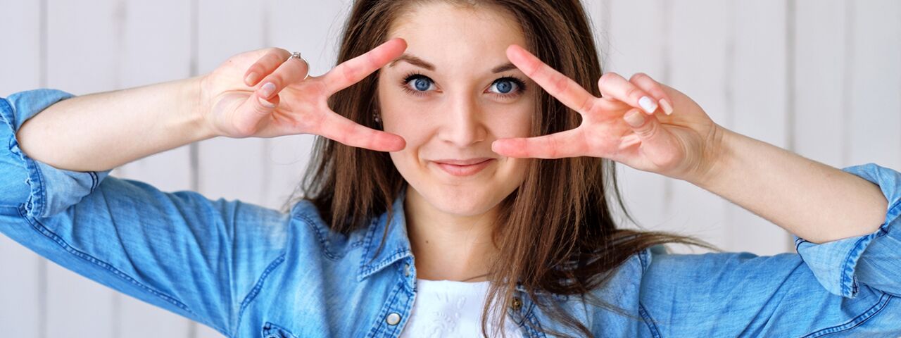 Happy Girl Holding Up Fingers to Her Eyes, Advert for LASIK