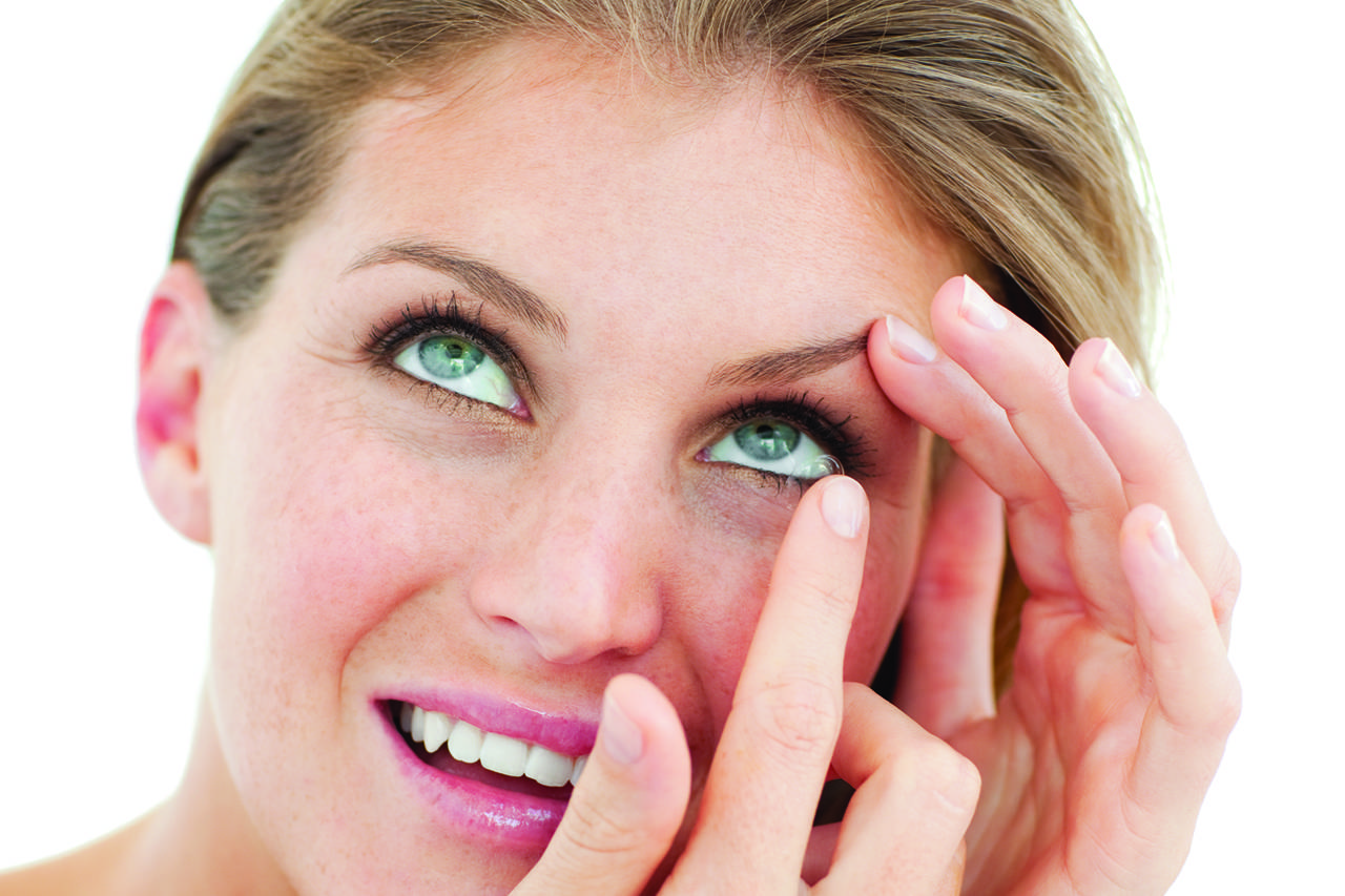 blonde woman putting in contact lenses