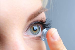 Eye doctor, woman putting on a daily disposable contact lens in Kissimmee & Lakeland, FL