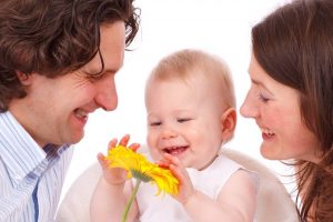 pediatric eye care in Florence, SC - caucasian mom, dad & baby with flower