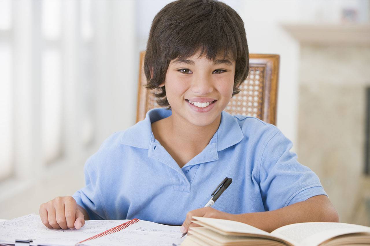 Boy in blue shirt doing homework - optometrist, Charlotte, NC