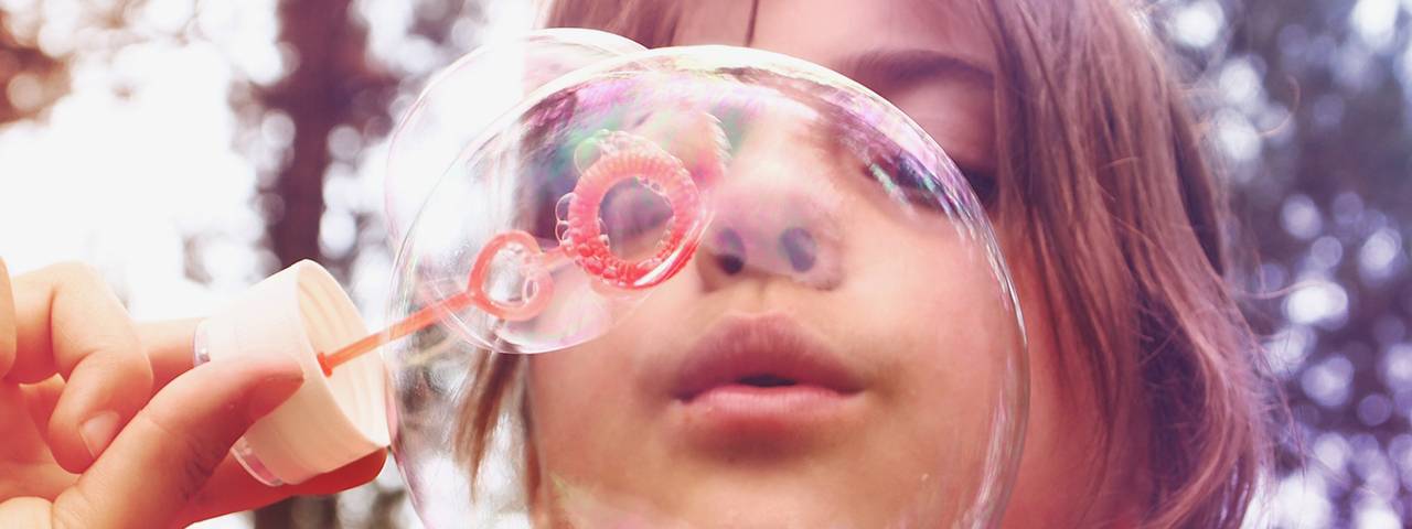 a girl is blowing bubbles