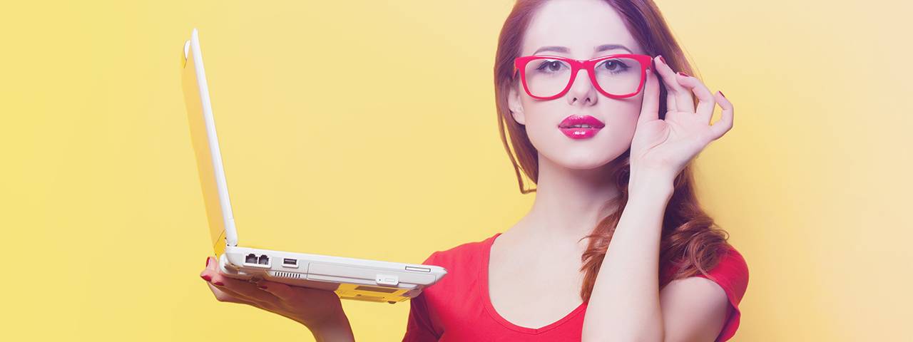 a woman holding a laptop red glasses