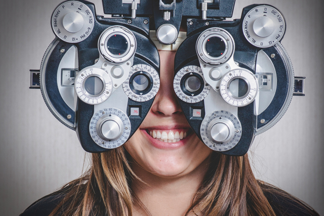 Woman behind a phoropter during eye exam