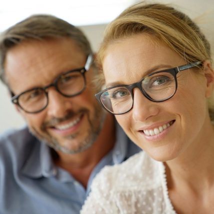 smiling middle aged couple modeling eyeglasses