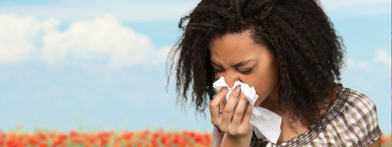 Woman with eye allergies, blowing her nose