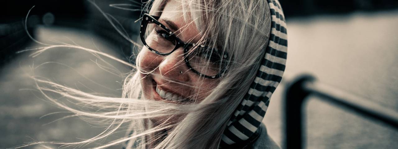 Girl wearing glasses on a windy day