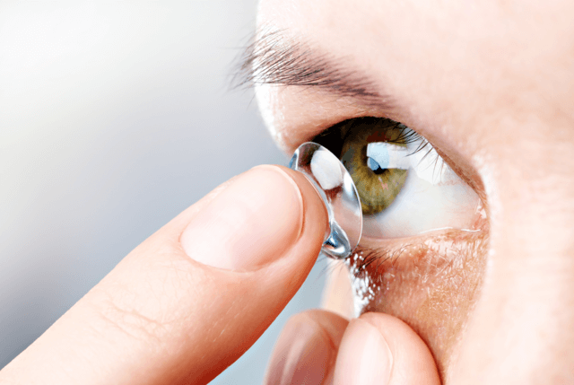 woman putting on a contact lens