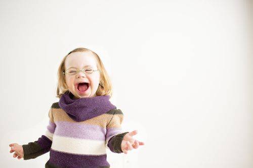 Smiling girl with Down Syndrome wearing glasses