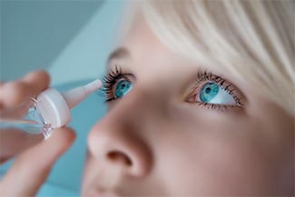 Optometrist, woman applying eyedroppers in Burnsville, Minnesota