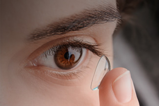 Girl With Brown Eyes Inserting a Contact Lens