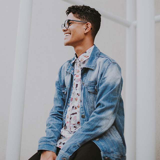 young man smiling denim glasses 640