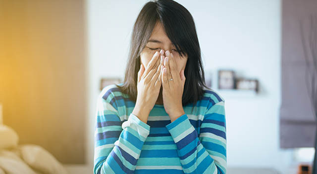 woman sneezing from eye allergies