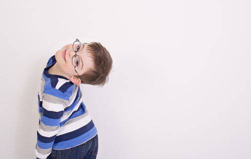 Boy wearing glasses in striped shirt leaning his head back in Glassboro, NJ