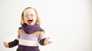 little girl with down syndrome wearing glasses and smiling