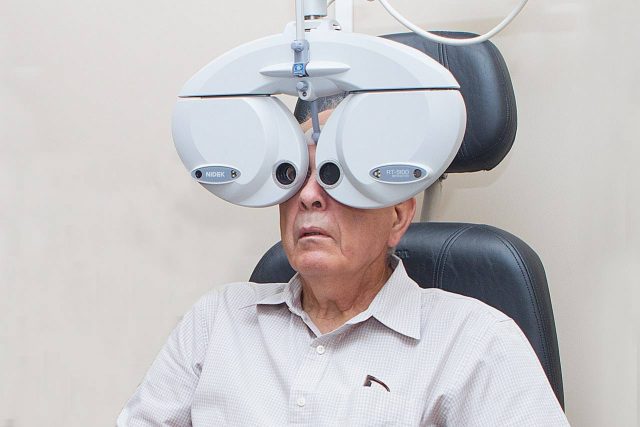Eye exam, senior man using a phoropter in Coppell, TX