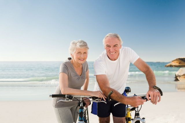 elderly couple cyclists beach