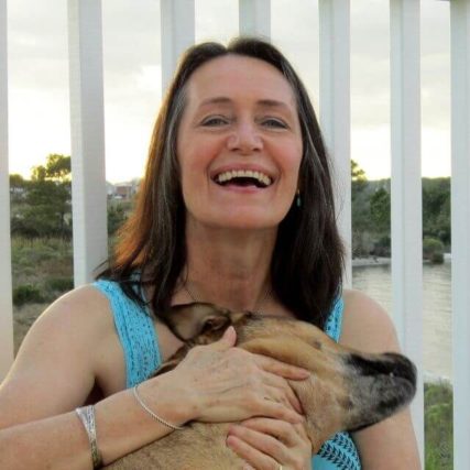 woman smiling huging a dog