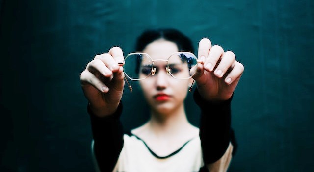 woman holding a pair of eyeglasses.jpg