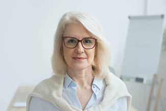 Confident Aged Businesswoman Wearing Glasses Looking At Camera,
