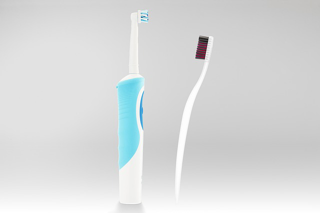 electric toothbrush next to regular toothbrush