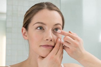 woman putting on contact lenses