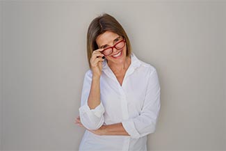 Woman Smiling And Holding Glasses