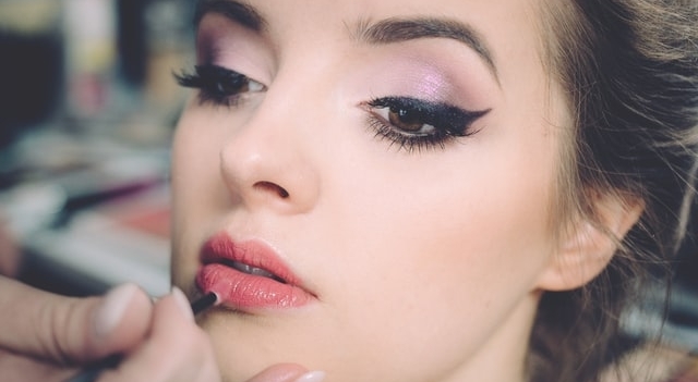 woman putting on makeup 640×350 1.jpg