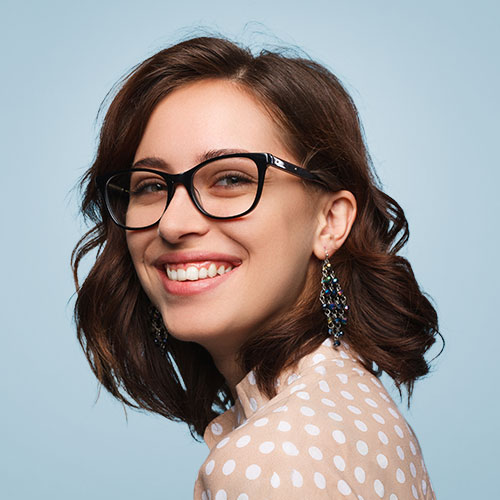 woman with glasses smiling wwith blue background