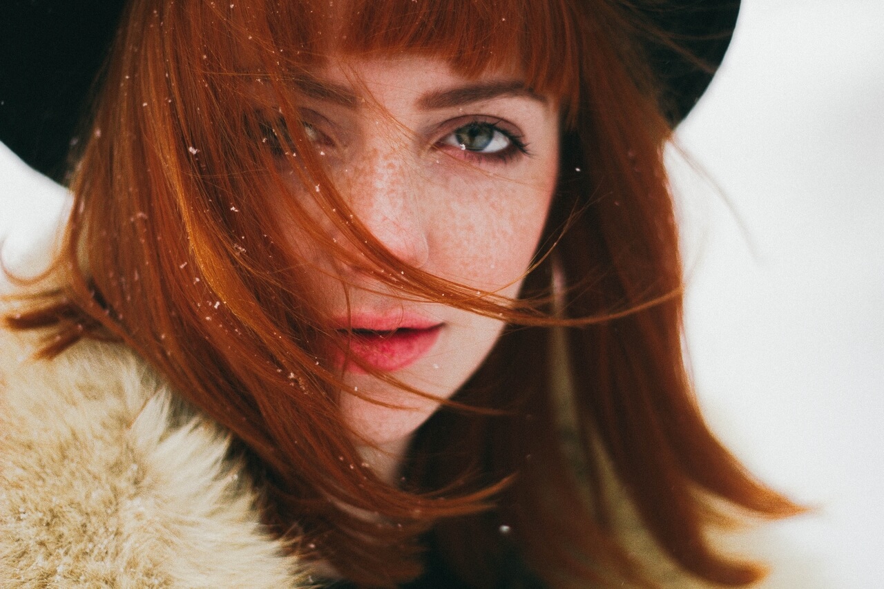 red-haired woman, with green eyes, in snow