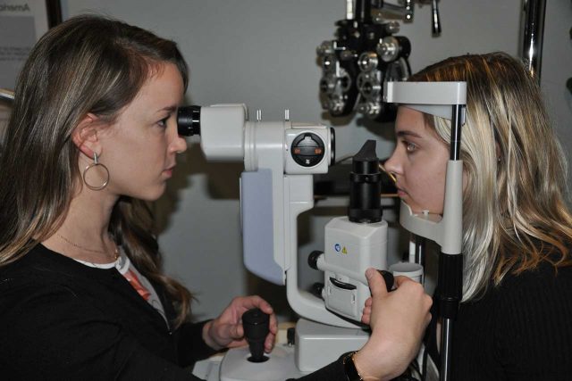 eye care, keratoconus patient taking her eye exam with optpmetrist