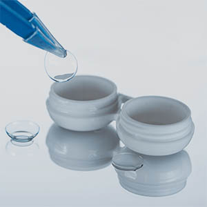 Close Up View Of Container For Contact Lenses And Tweezers On Wh
