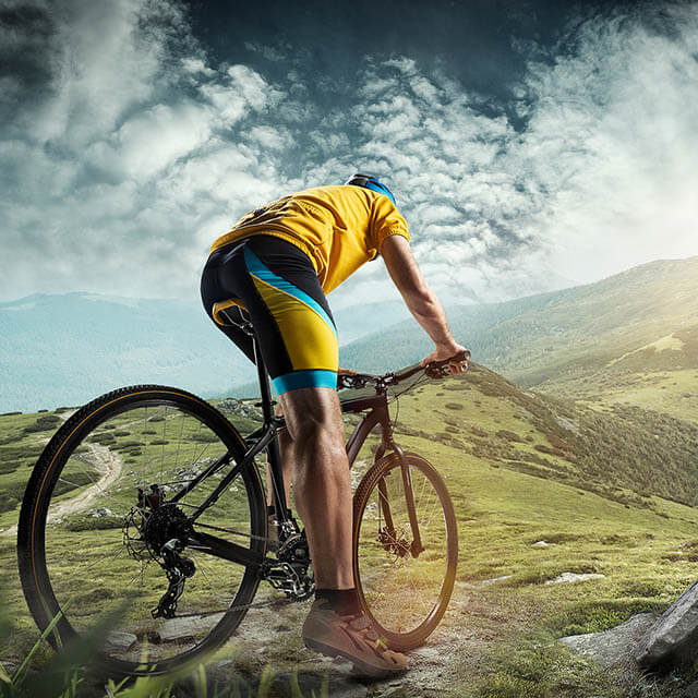 The Young Fit Man In Helmet Conquering Mountains On A Bicycle. T