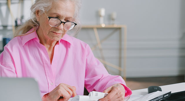 elderly woman reading with glasses