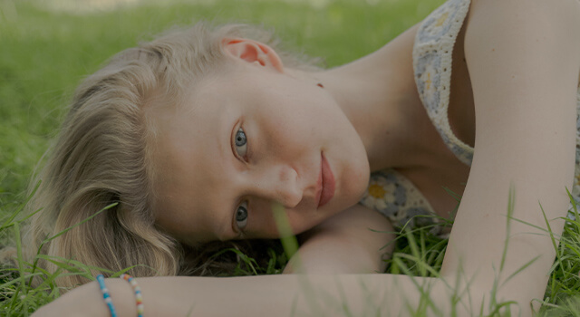 blonde woman lying in the grass