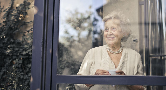 older woman with macular degeneration looking out the window