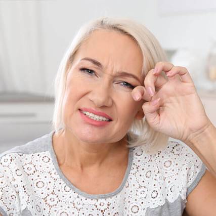 elderly lady touches her eye - eye emergency