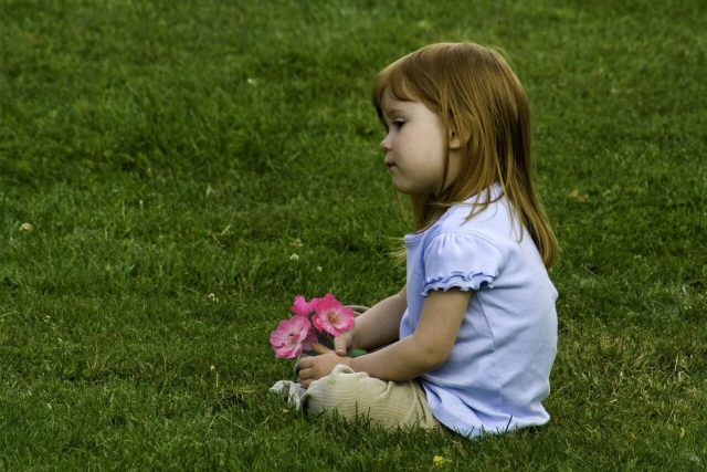 Young Girl Sitting in Grass