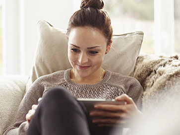 Women relaxing on couch with tablet pc
