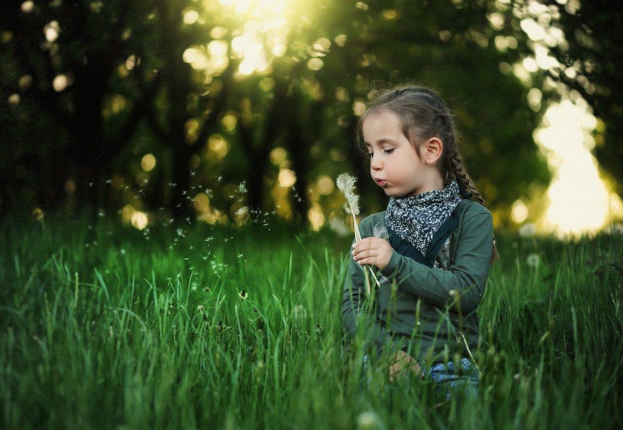 girl in the grass, wearing scleral lens