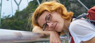 Redhead woman wearing glasses, laying down