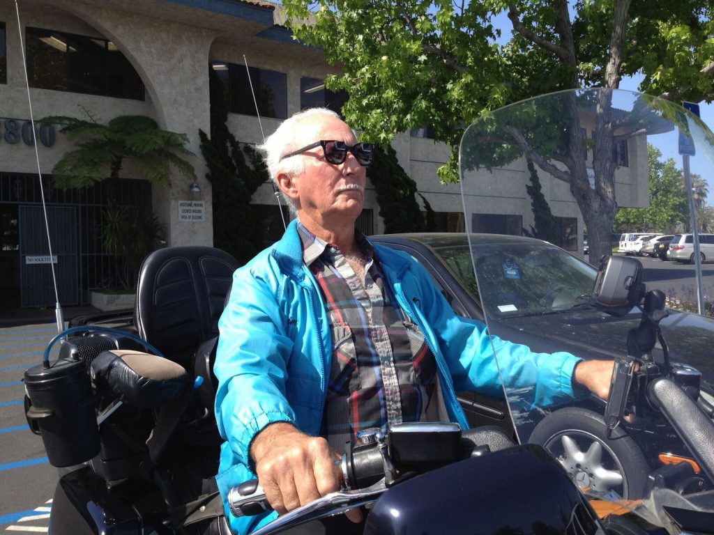 senior man riding motorcycle with low vision aids