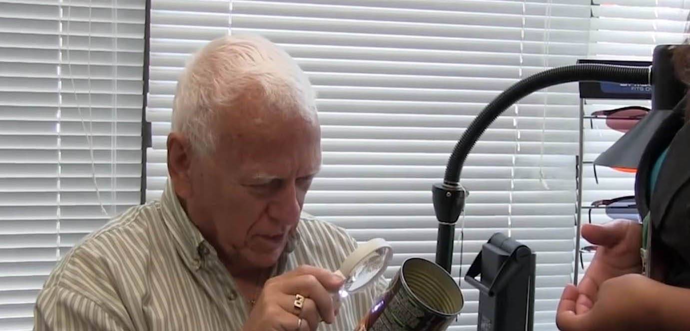 Man using handheld magnifier for low vision