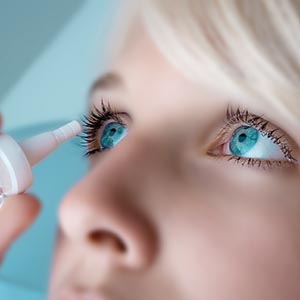 Woman putting eye drops in her eyes, Eye Care in Colorado Springs, CO
