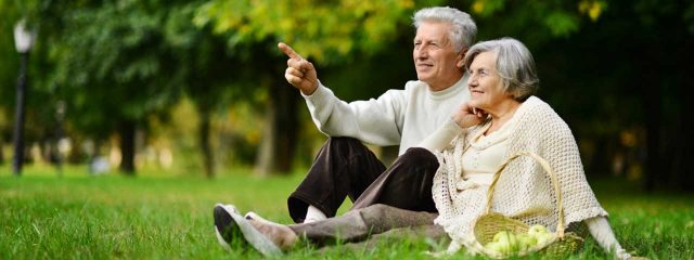 senior couple sitting in park with macular degeneration